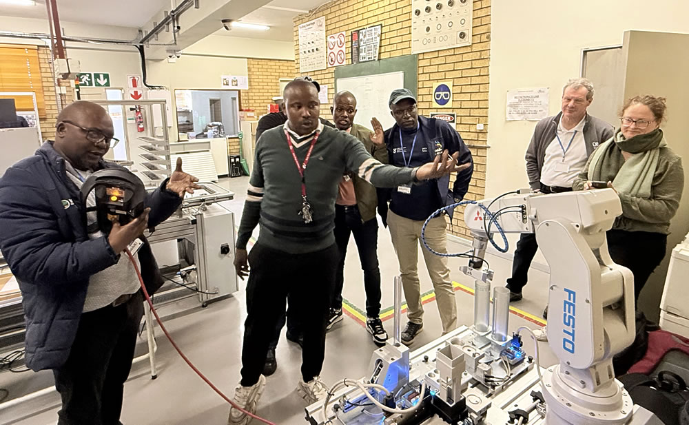 Calvin Hlatshwayo training some of the lecturers on how to operate 
                and control industrial robots using a simulated robot system